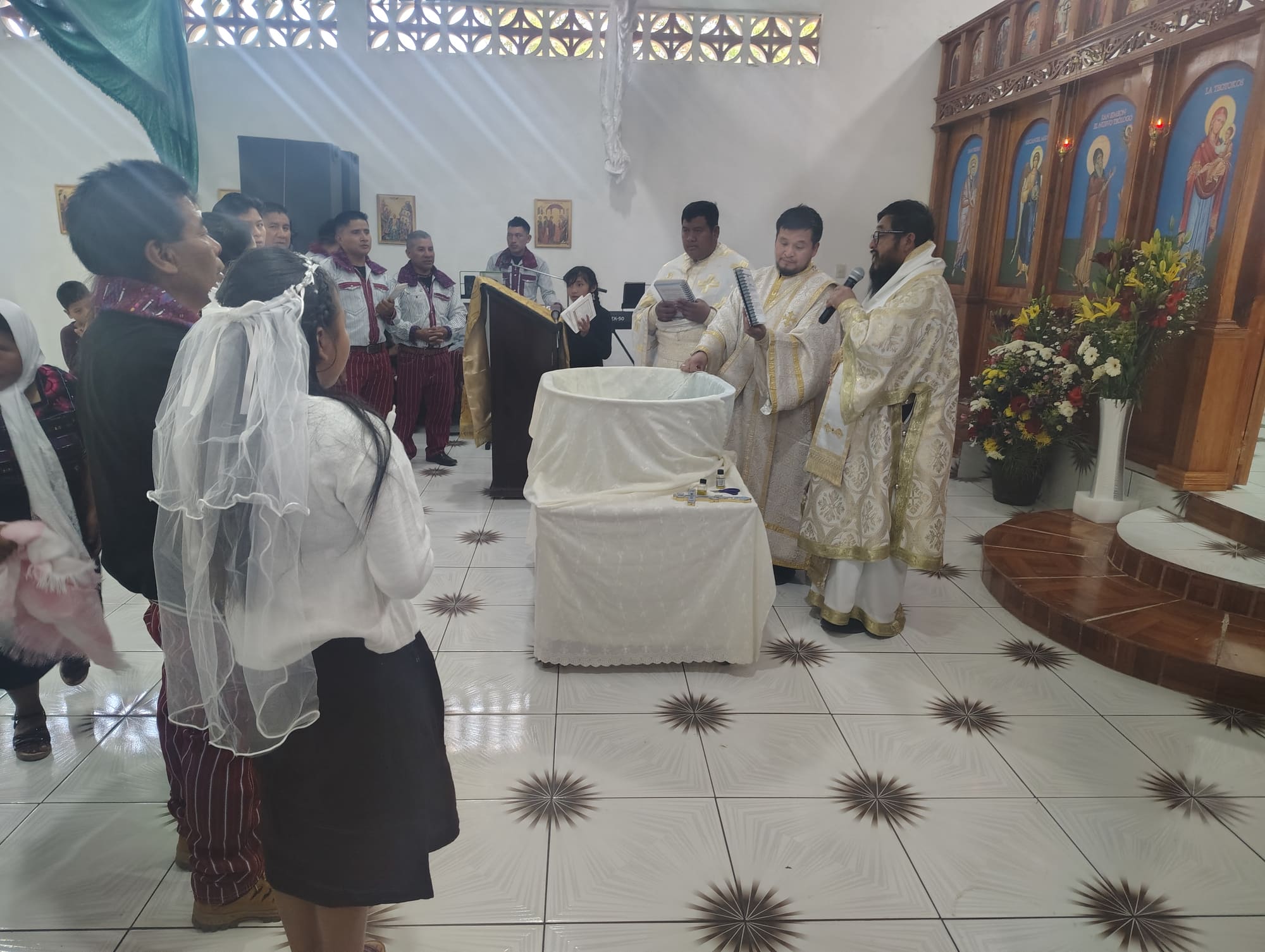 Women in white veils and clergy in gold vestments during a liturgy